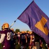 Janson Cunningham carries the school flag onto the field prior to Friday's game against Hanford.